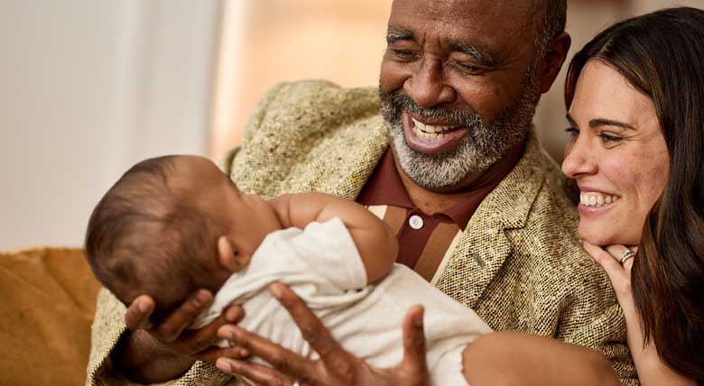 photo of two adults holding a newborn baby