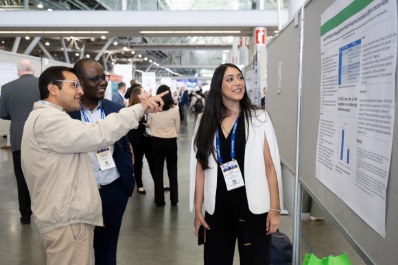 ID/CCM Fellow standing in front of research display