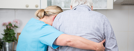 A nurse helping a senior citizen walk.