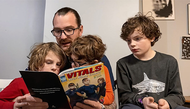 AHN Nurse reading the Marvel's graphic novel The Vitals - True Nurse Stories to his sons.