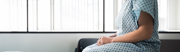 woman in gown sitting in doctor’s office