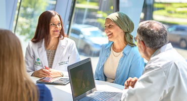 AHN staff talking to a patient around a table in a meeting room