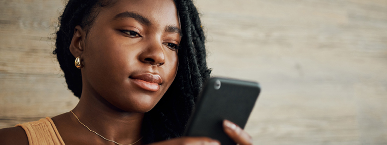 Woman using her smartphone to schedule a skin cancer screening appointment with AHN.