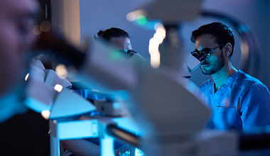 Researchers at AHN conducting skin cancer research using microscopes.