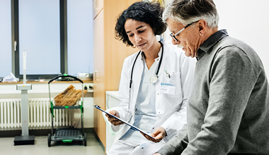 Doctor discussing squamous cell skin cancer treatment options with a patient during a consultation.