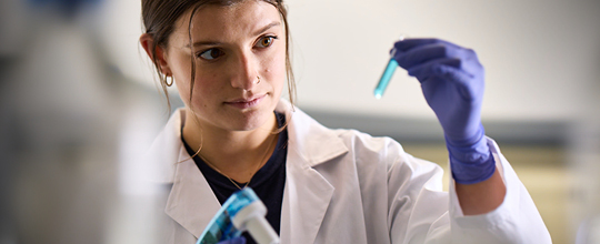 Researcher in a lab analyzing a sample for immunotherapy research related to squamous cell carcinoma.