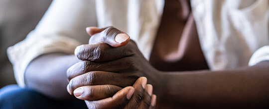 A close up view of a patient clasping their hands together