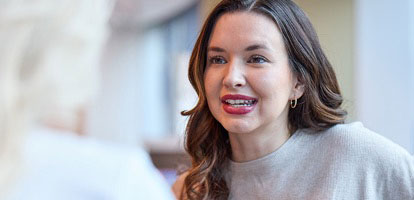 AHN patient smiling while talking to an cancer specialist.