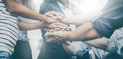 A group of people doing a huddle and a hand stack together.