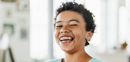 A young girl with braces smiling.