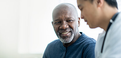 A patient smiles while consulting with a doctor about pain management options.