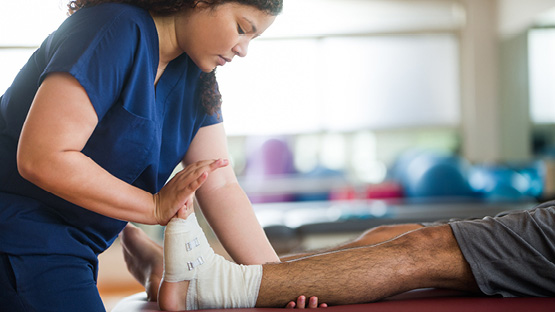 An occupational therapist working on a patient's foot.