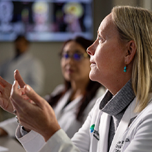 A female medical specialist is looking upwards to the left.