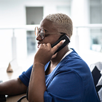 Woman sitting at a desk holding phone to her ear