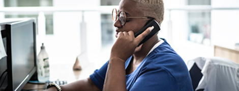 Woman sitting at a desk holding phone to her ear